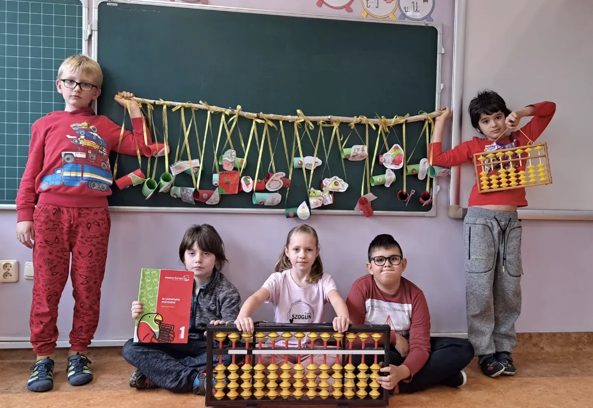 Pupils presenting abacuses and workbooks