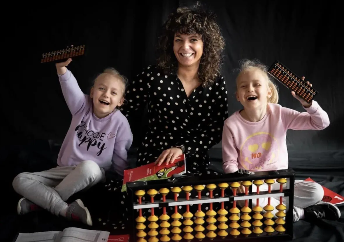Teacher and children with abacuses